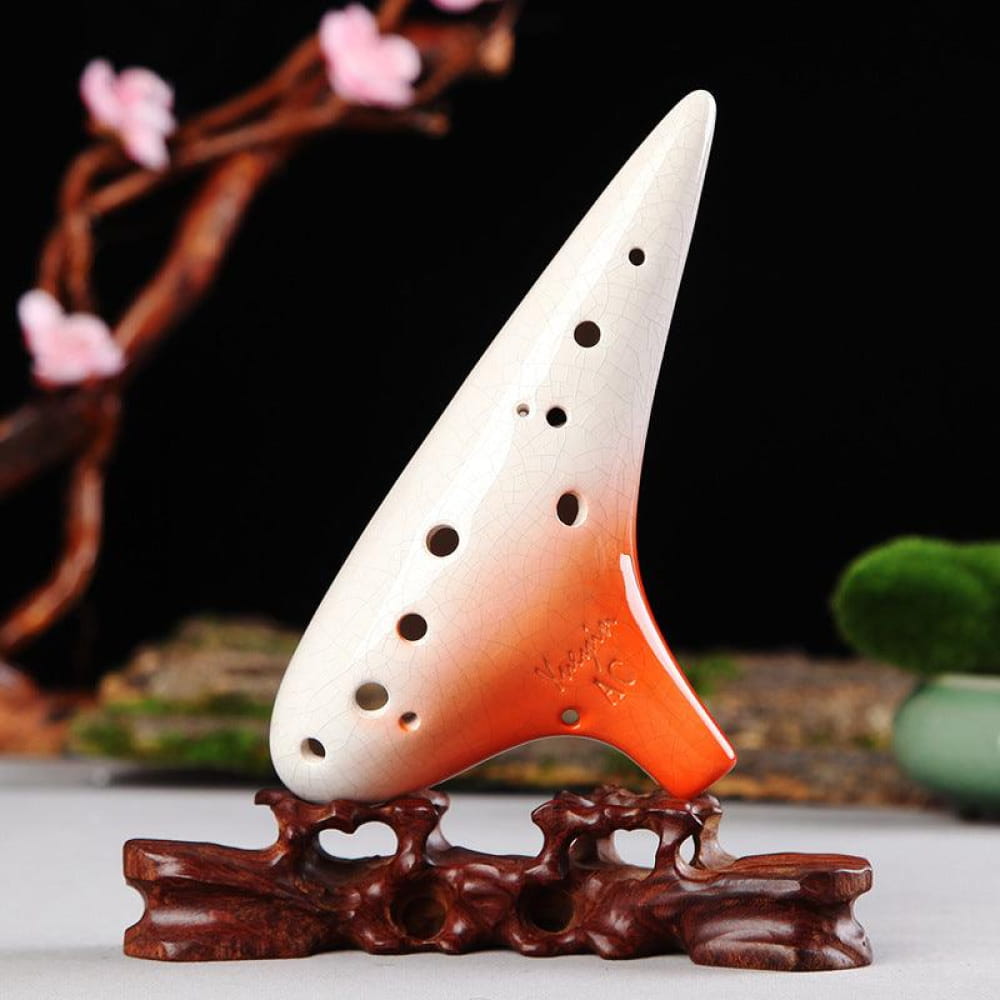 White and orange ceramic ocarina on wooden stand in 12 Hole Tenor Alto C Ocarina Flute