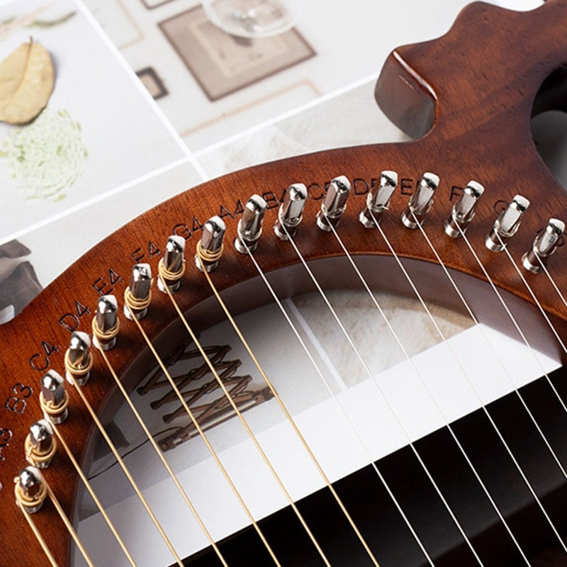 Close-up of guitar tuning pegs and strings on a wooden headstock of a Lyre Harp