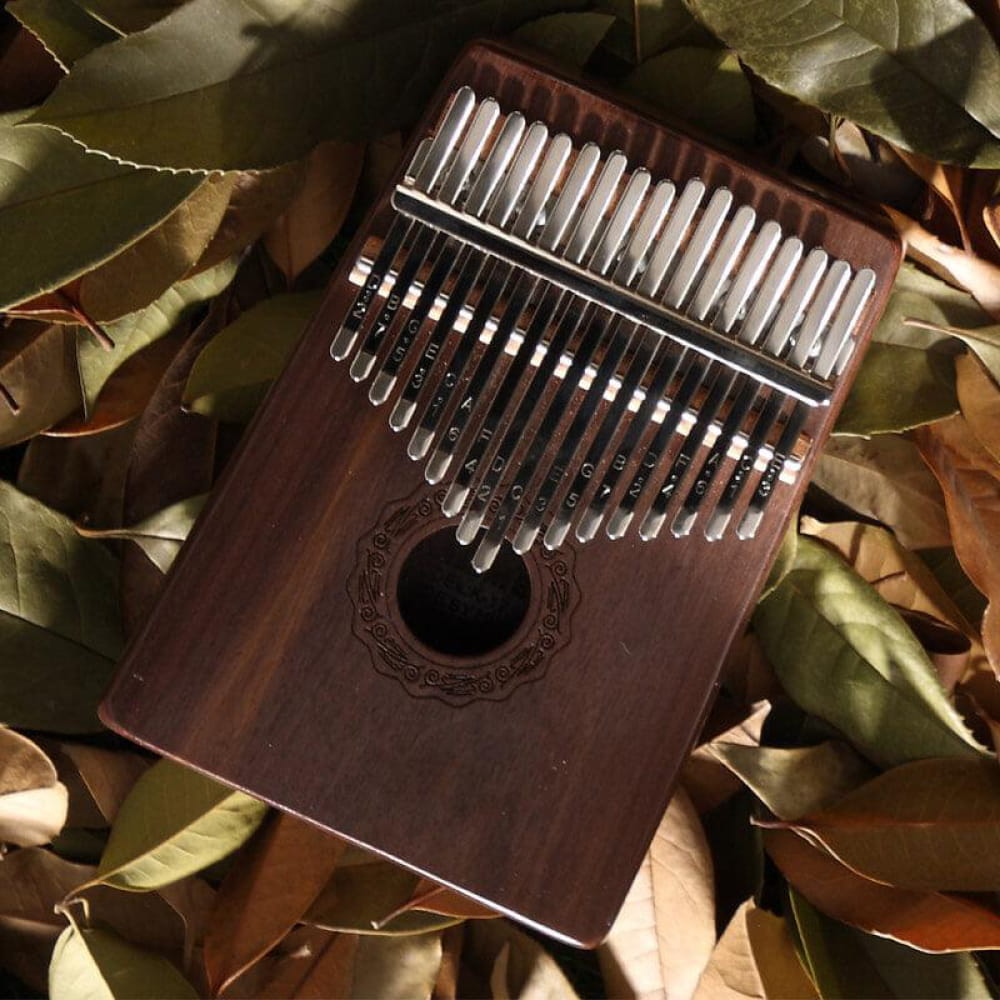 Wooden Kalimba thumb piano with metal tines and decorative sound hole in Walnut design
