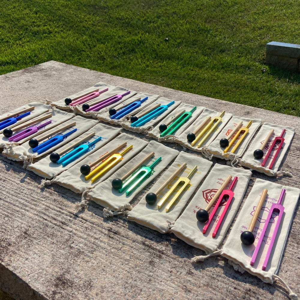 Colorful pens and markers in fabric holders beside 17-Piece Solfeggio Chakra Tuning Fork Set
