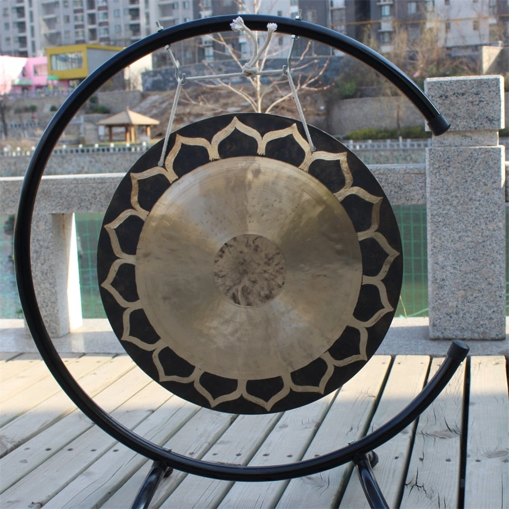 Traditional Chinese gong on a black metal stand for meditation and relaxation