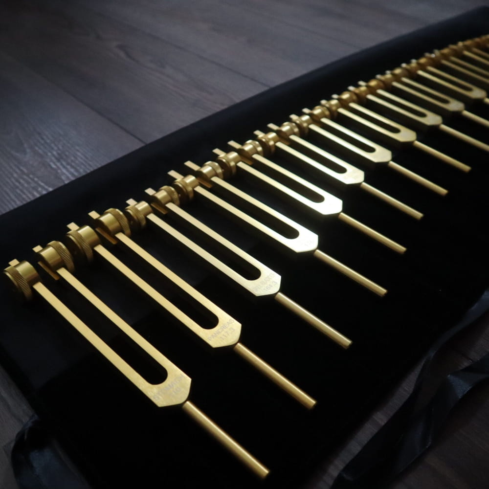 Row of golden tuning forks in 24pc Solfeggio Tuning Fork Set for Sound Healing