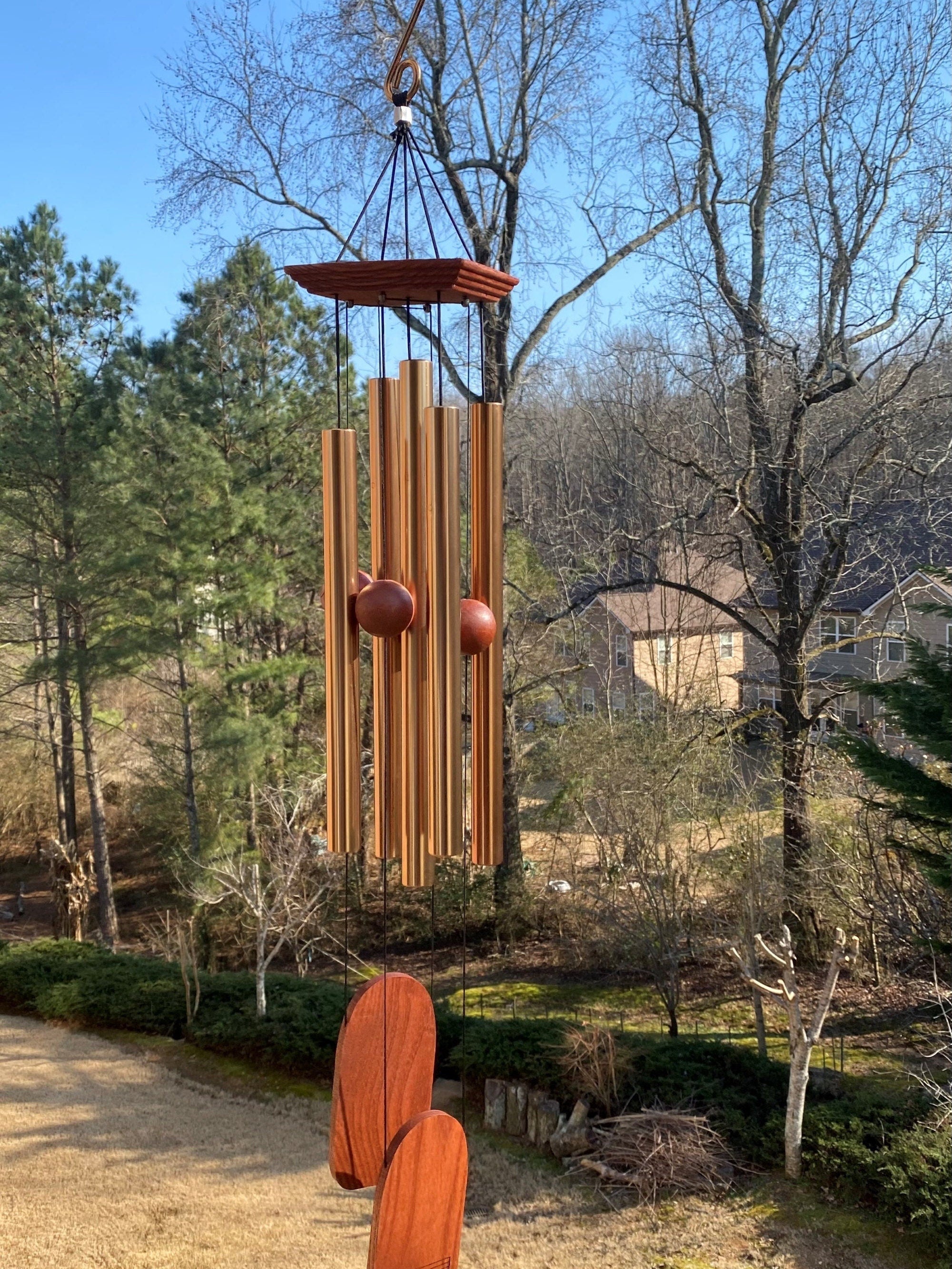 Wooden wind chime with hanging tubes and circular chimes in memorial design