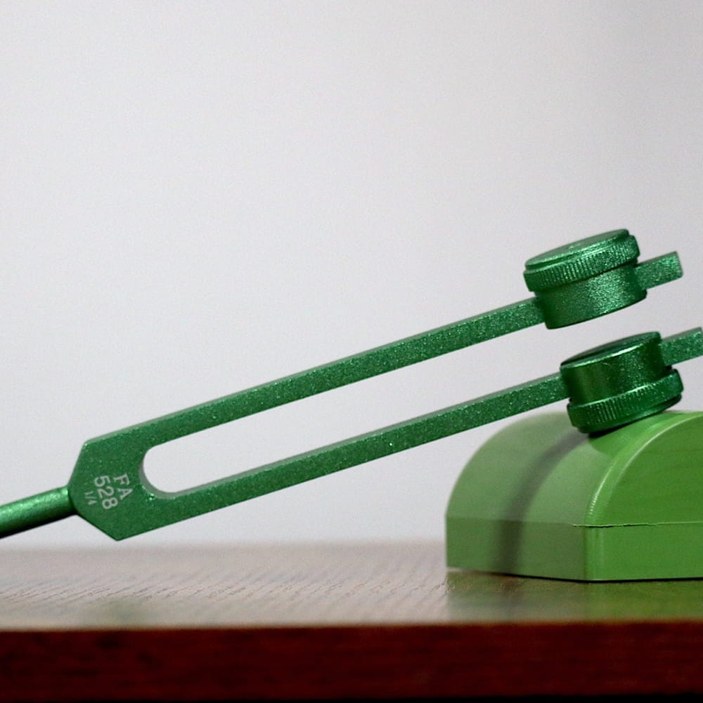 Green 528 Hz Solfeggio Tuning Fork with circular base for healing therapy and chakra balancing