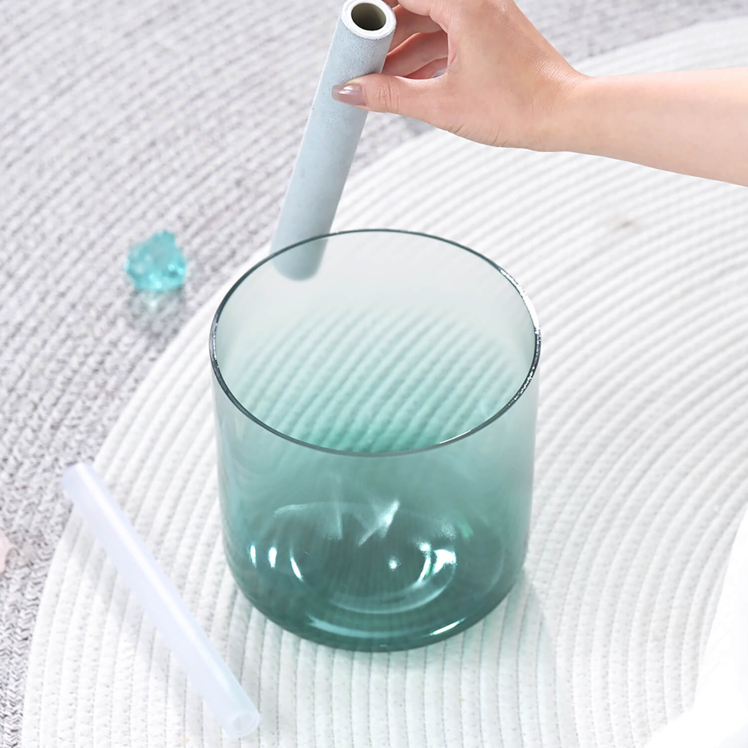 Teal glass tumbler and straws beside Quartz Crystal Singing Bowl for meditation