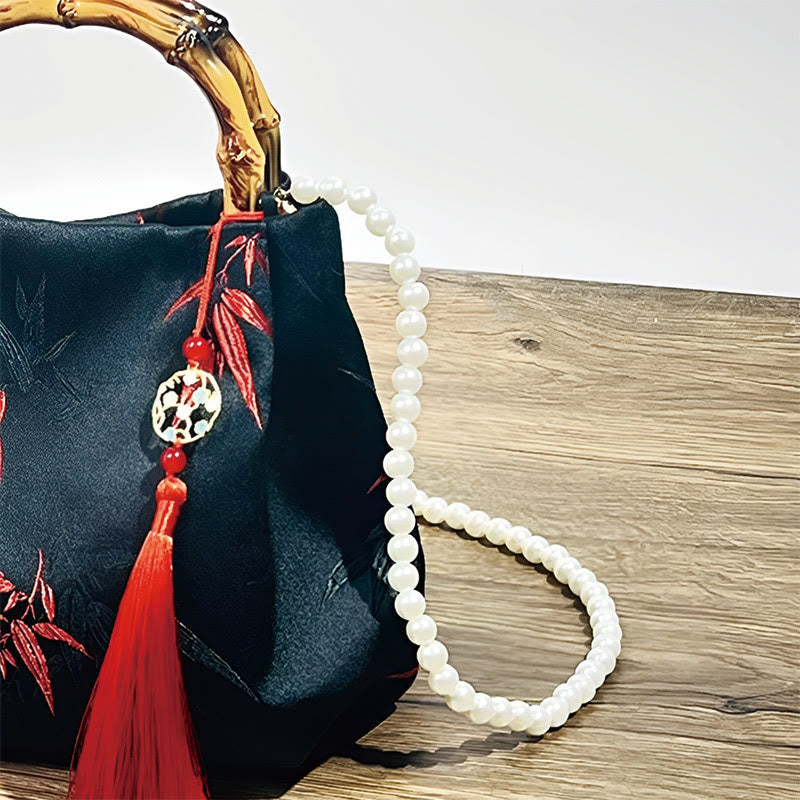 Schwarze Tasche aus Polyester-Baumwolle mit bestickten Blättern und Bambusgriff