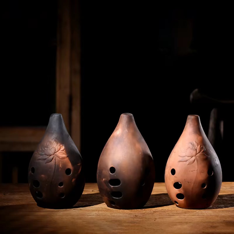 Three teardrop-shaped ceramic ocarina flutes with leaf designs in Ceramic Xun instrument
