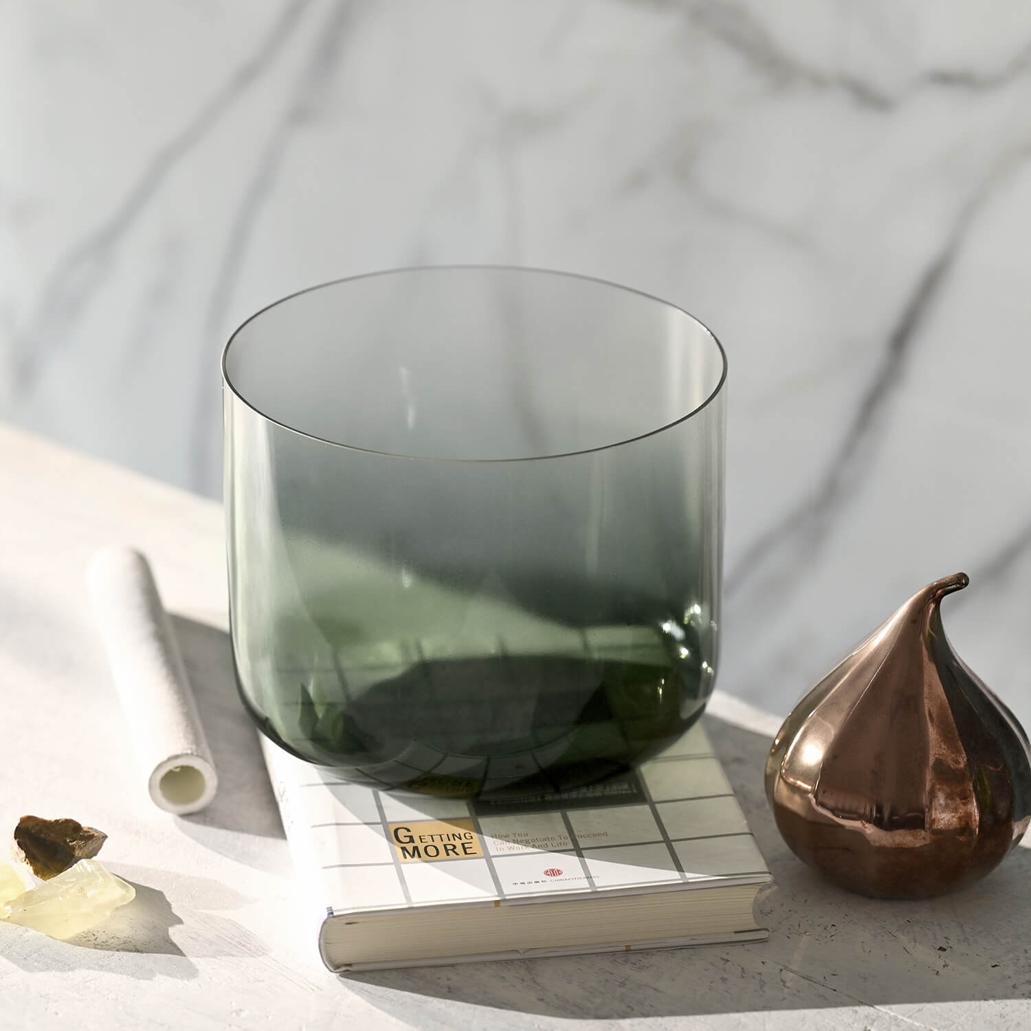 Smoky green glass tumbler beside Crystal Quartz Singing Bowl for meditation healing