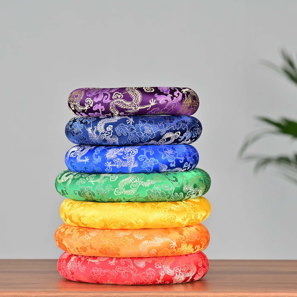 Stack of seven colorful meditation cushions in rainbow order for Crystal Singing Bowl