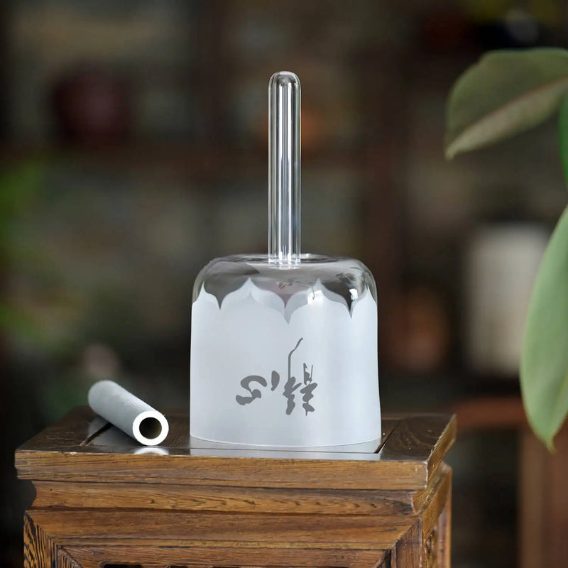 A translucent white glass incense burner with a frosted, scalloped base and an engraved chinese character design.