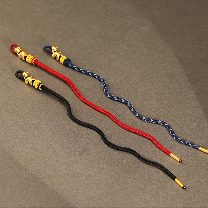 Goldfarbenes Schlangenarmband mit roter Schnur für Stärke und Schutz