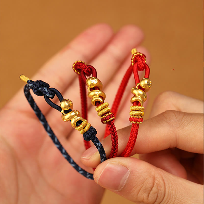 Goldfarbenes Schlangenarmband mit roter Schnur für Stärke und Schutz