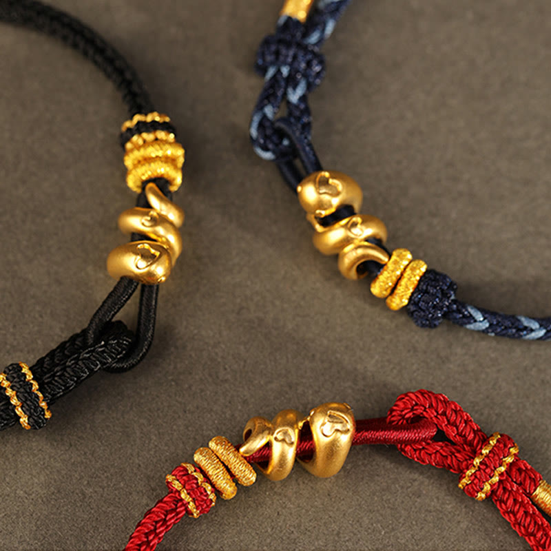 Goldfarbenes Schlangenarmband mit roter Schnur für Stärke und Schutz