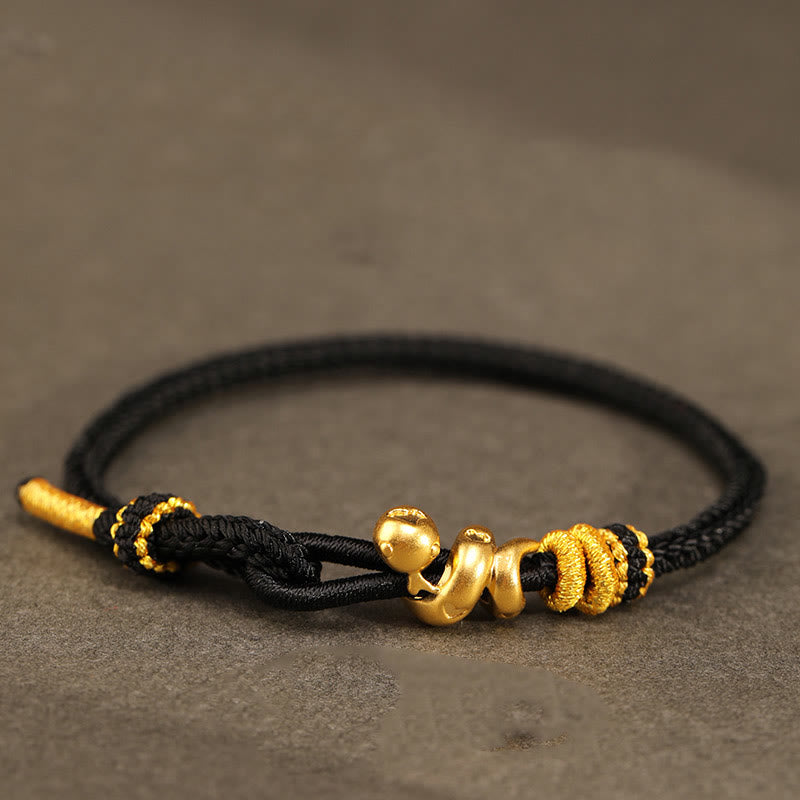 Goldfarbenes Schlangenarmband mit roter Schnur für Stärke und Schutz
