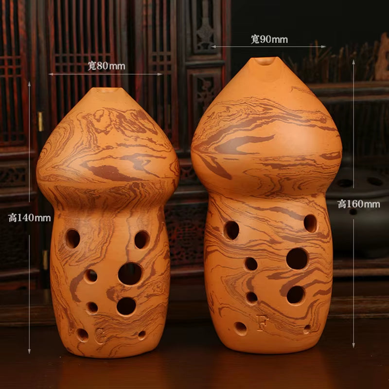 Two decorative ceramic ocarinas featuring multiple finger holes in traditional style