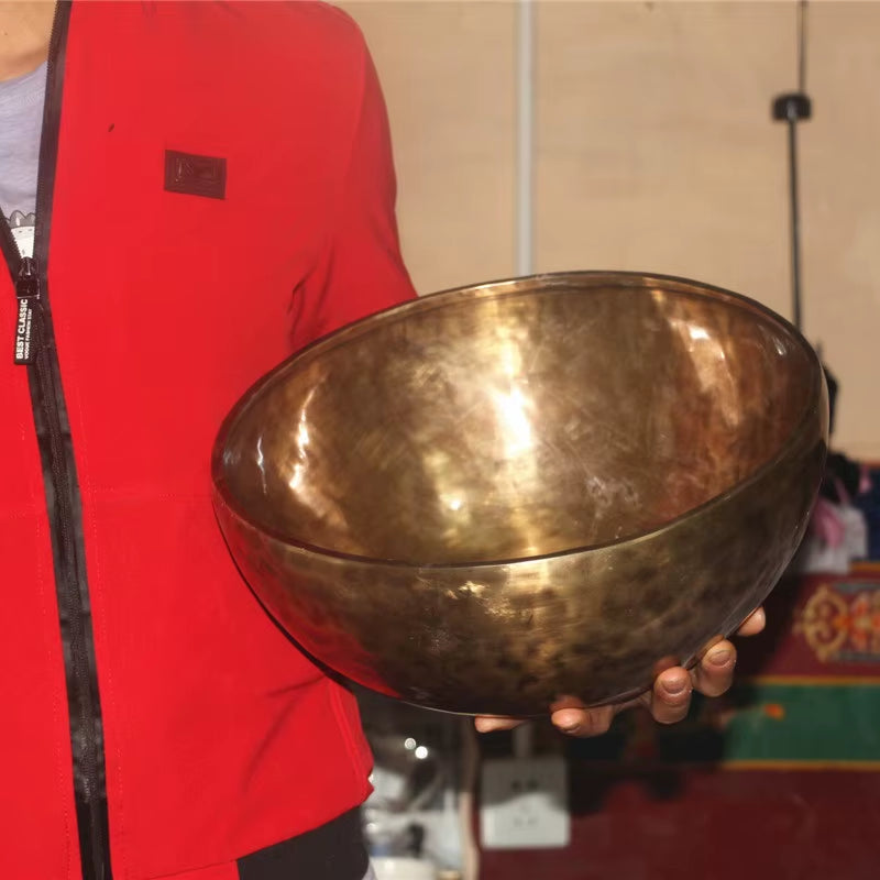 Hammered brass Singing Bowl held to show its metallic surface in Nepal Handmade design