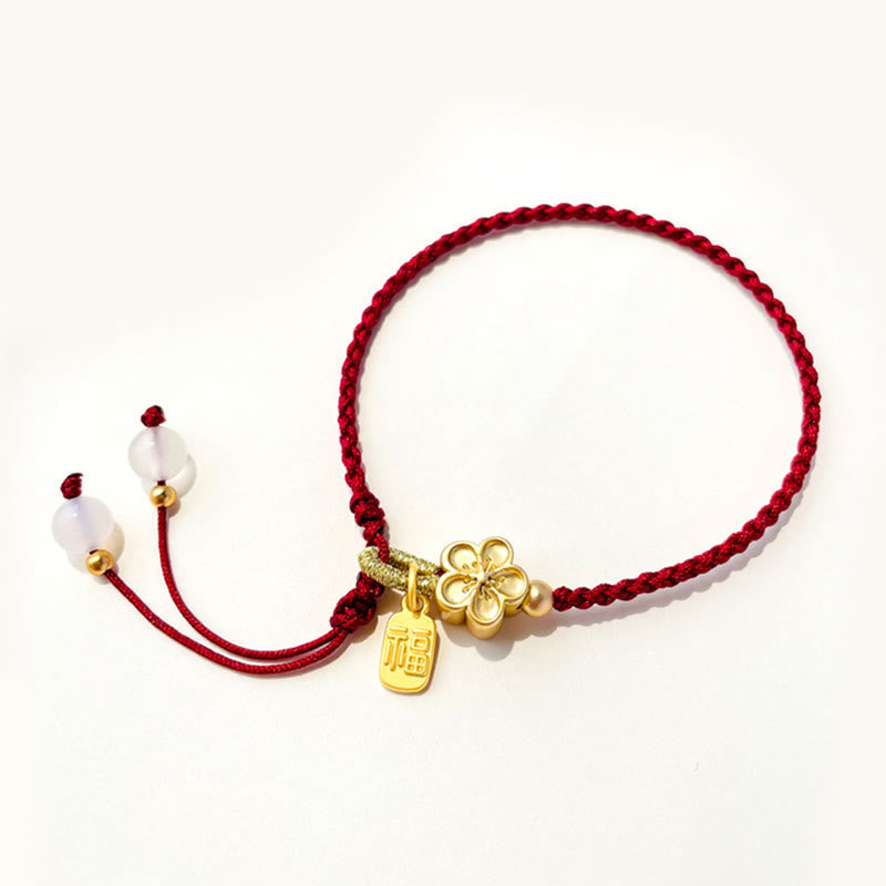 Rotes Schnurarmband mit Fu-Charm-Anhänger und Pfirsichblüten-Detail