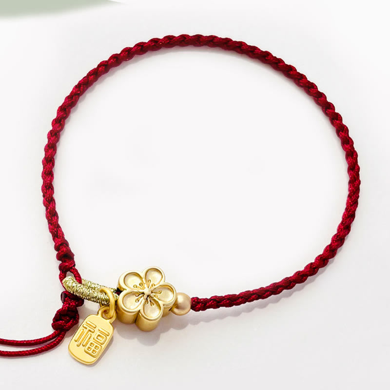 Rotes Schnurarmband mit Fu-Charm-Anhänger und Pfirsichblüten-Detail