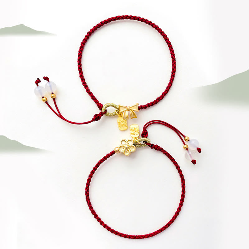 Rotes Schnurarmband mit Fu-Charm-Anhänger und Pfirsichblüten-Detail