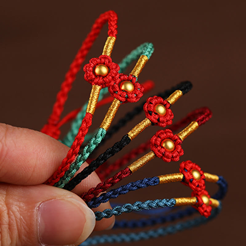 Rotes Schutzarmband mit goldener Blume