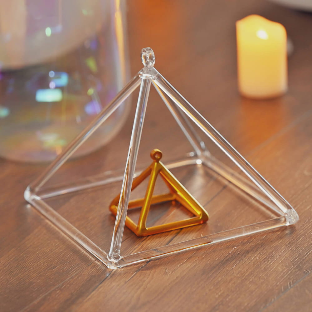 Clear glass pyramid structure featuring a smaller golden pyramid inside Triangle Crystal Singing Pyramid