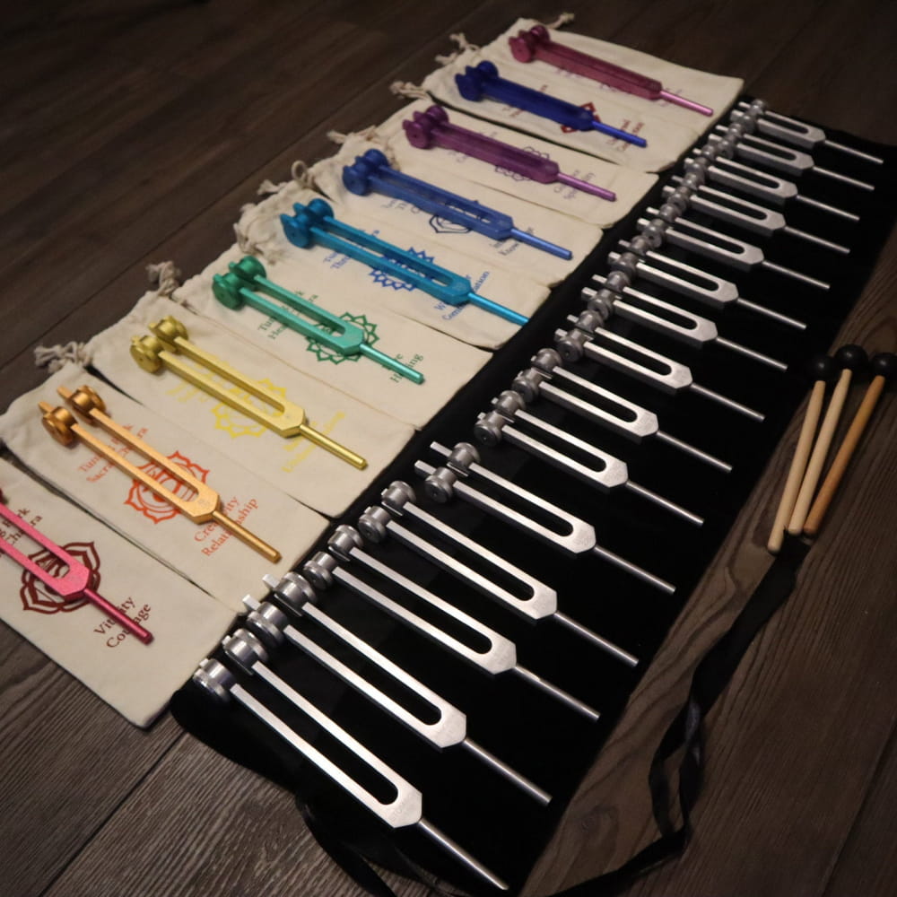 Colorful tuning forks on dark surface from 24pc Human Biology & Solfeggio set for healing