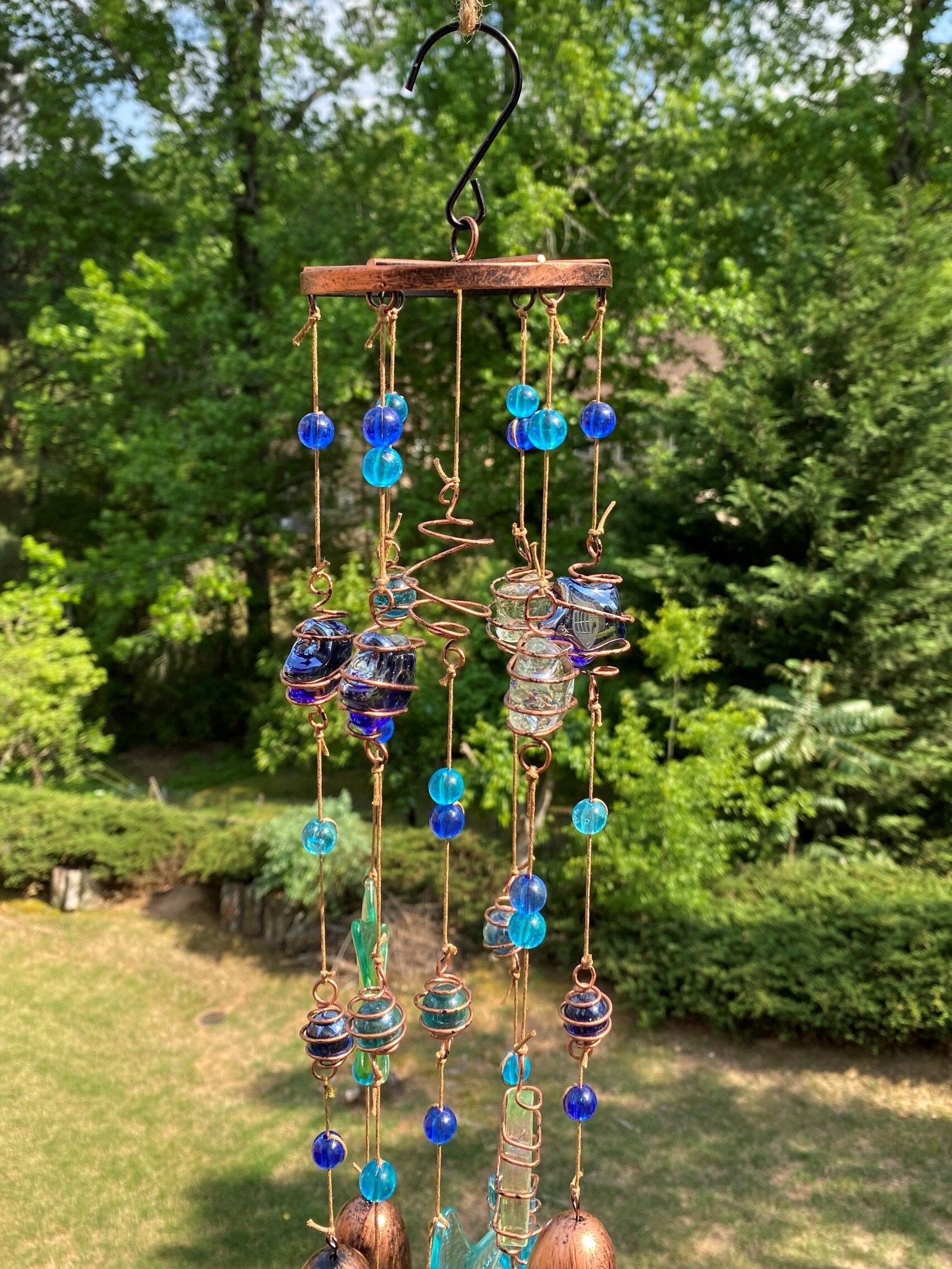 Decorative wind chime with blue glass beads and copper coils on wooden discs