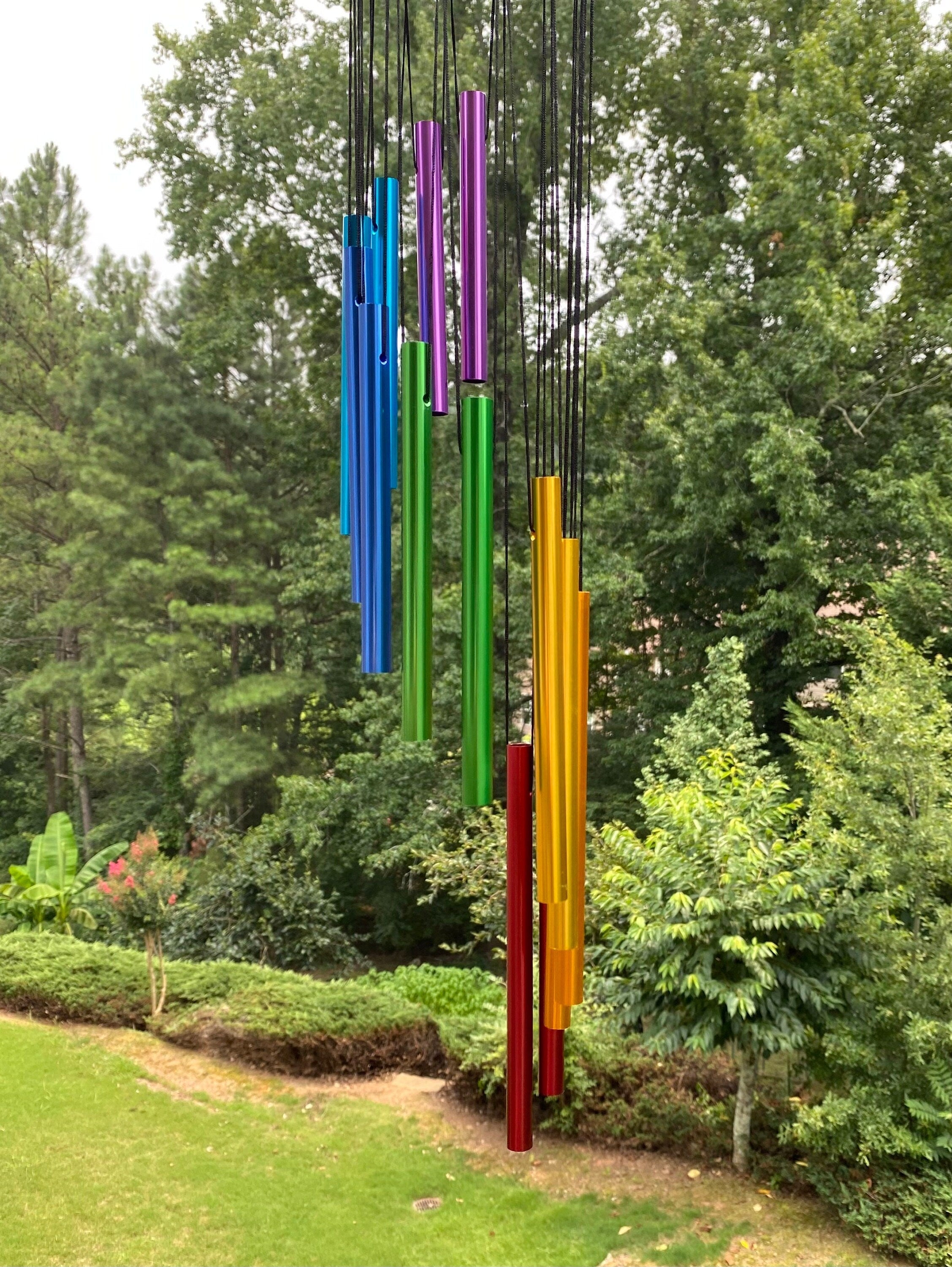 Rainbow-colored wind chimes hanging vertically in a row for outdoor decoration