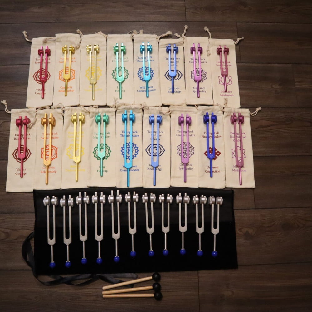 Rainbow-colored tuning forks for chakra healing on fabric in the 28pc set