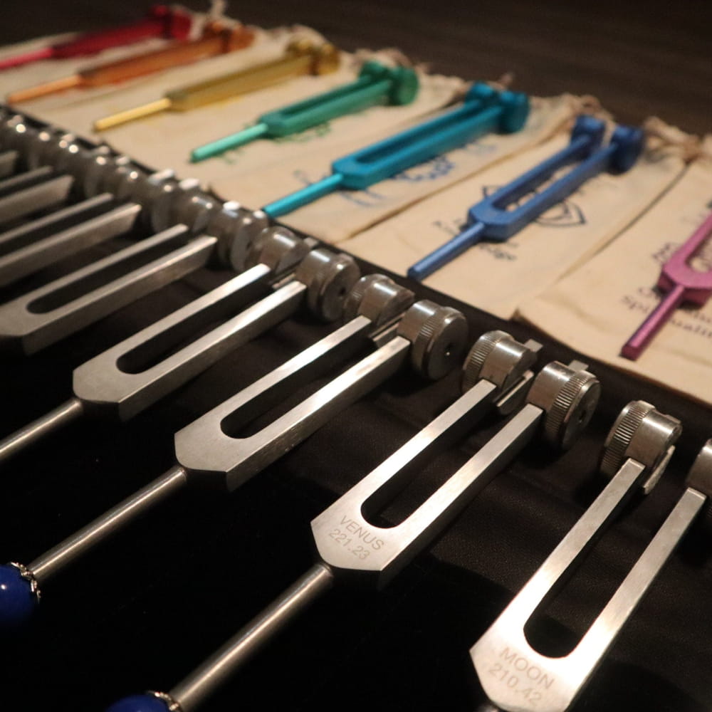 Colorful tuning forks arranged side by side in a Chakra healing set