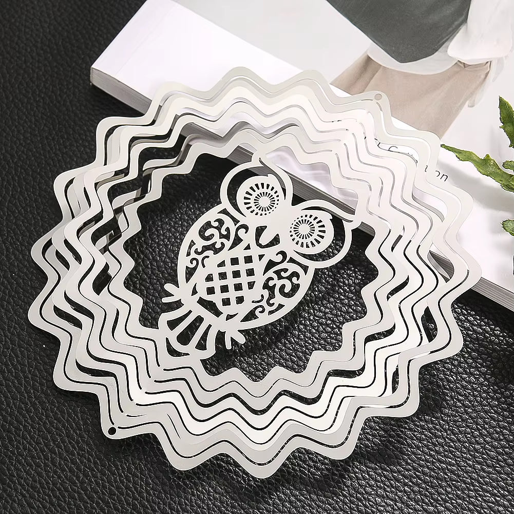 White metal wind spinner featuring an owl design and wavy circular patterns