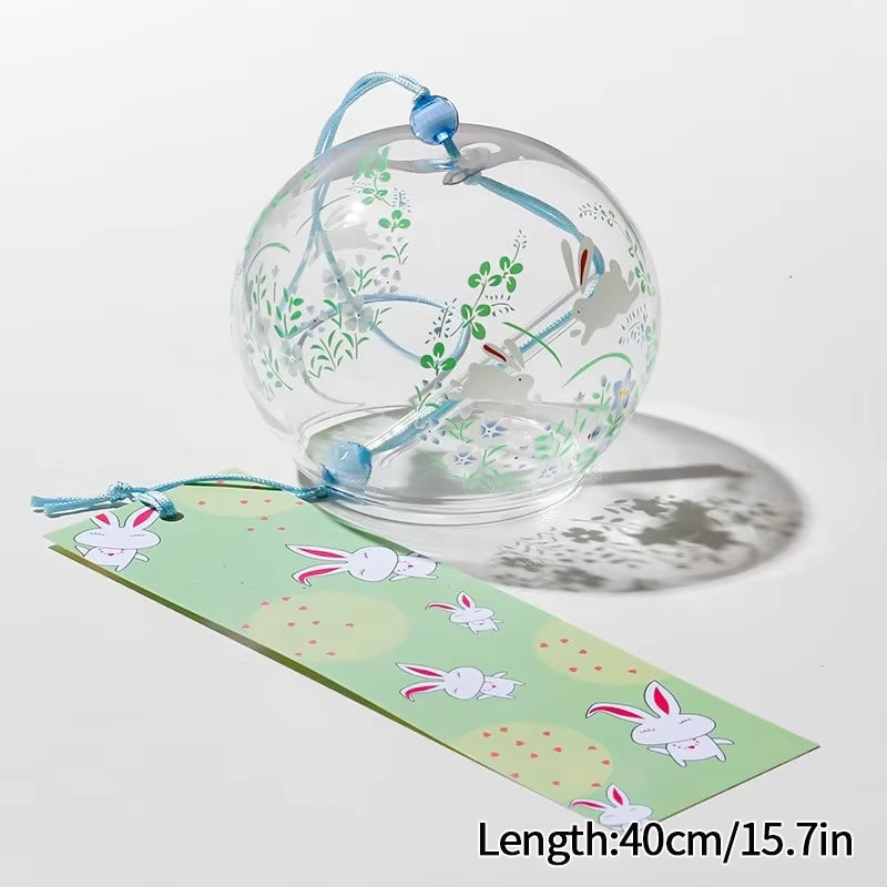 Clear glass wind chime with green floral patterns and bunny paper strip for outdoor decor