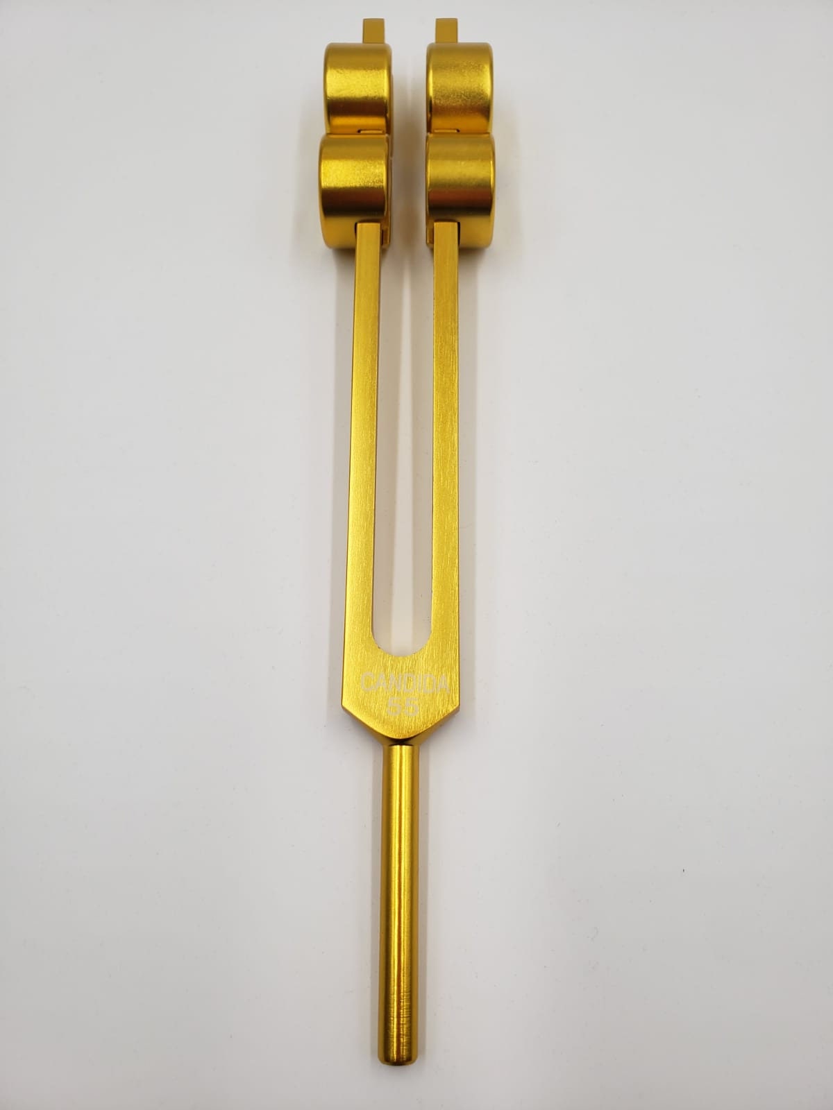 Gold-colored 55 Hz Candida Tuning Fork with cylindrical weights and pouch for healing