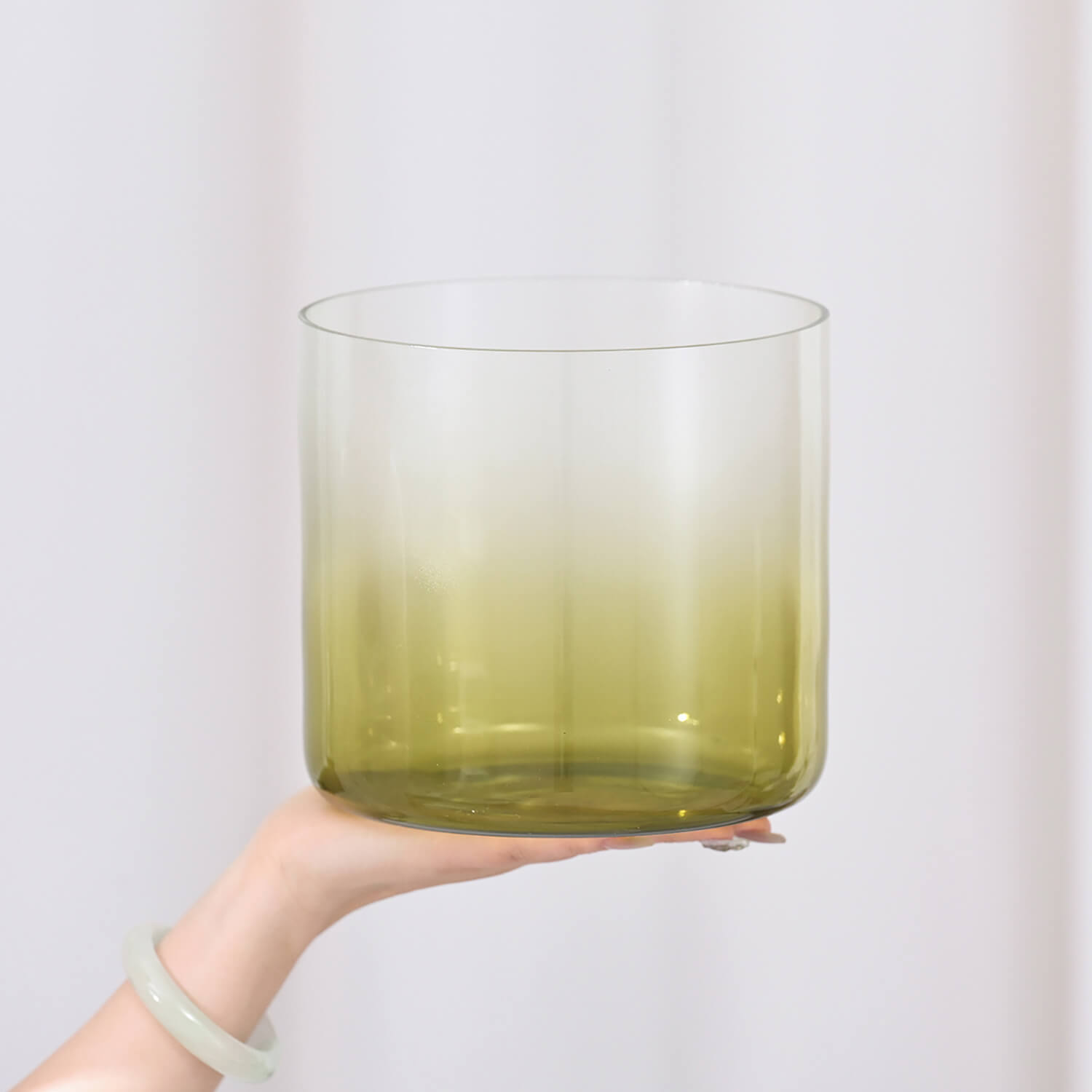 Gradient-tinted drinking glass transitioning from clear to olive green for meditation