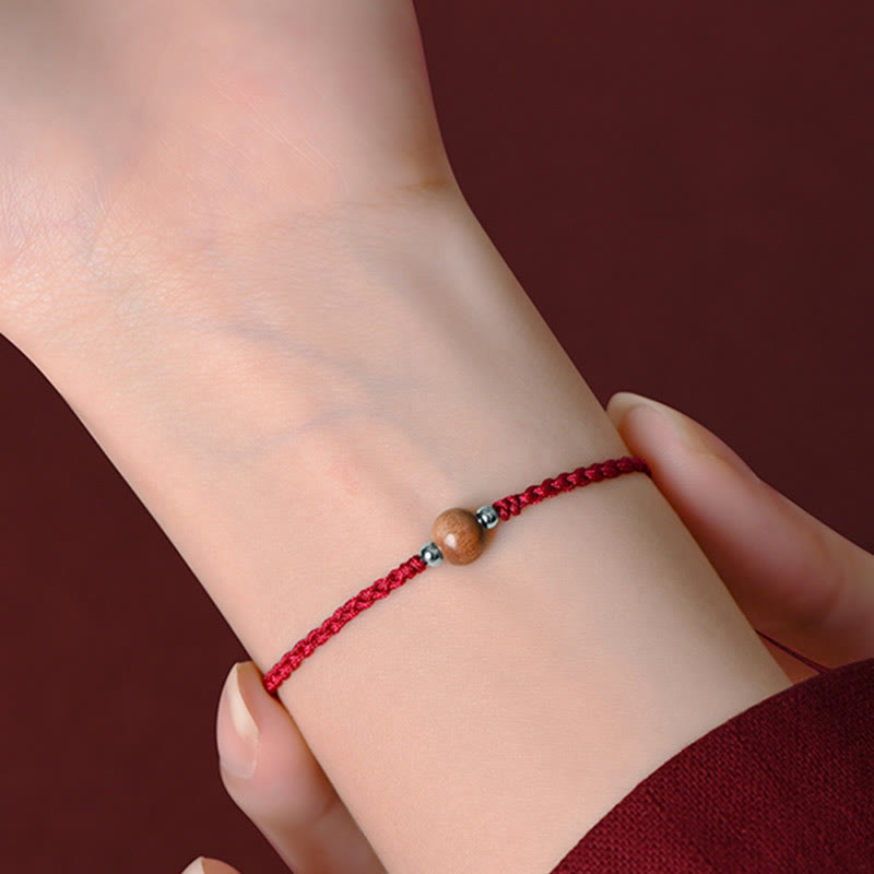 6 mm Schutzarmband aus Pfirsichholz mit roter Schnur