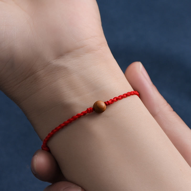 6 mm Schutzarmband aus Pfirsichholz mit roter Schnur