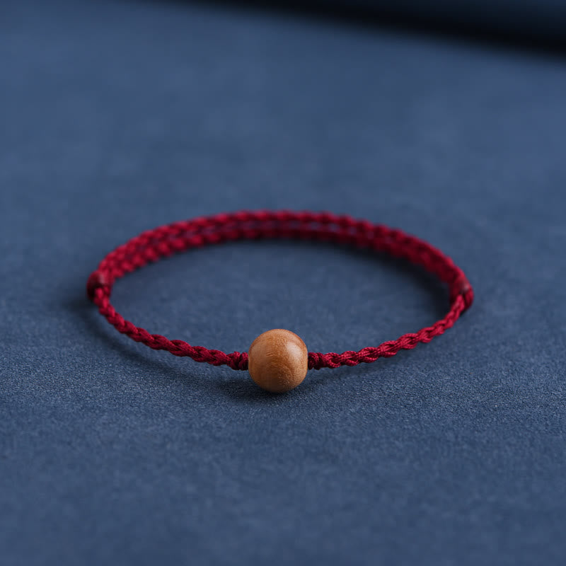 6 mm Schutzarmband aus Pfirsichholz mit roter Schnur