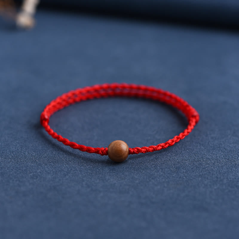 6 mm Schutzarmband aus Pfirsichholz mit roter Schnur