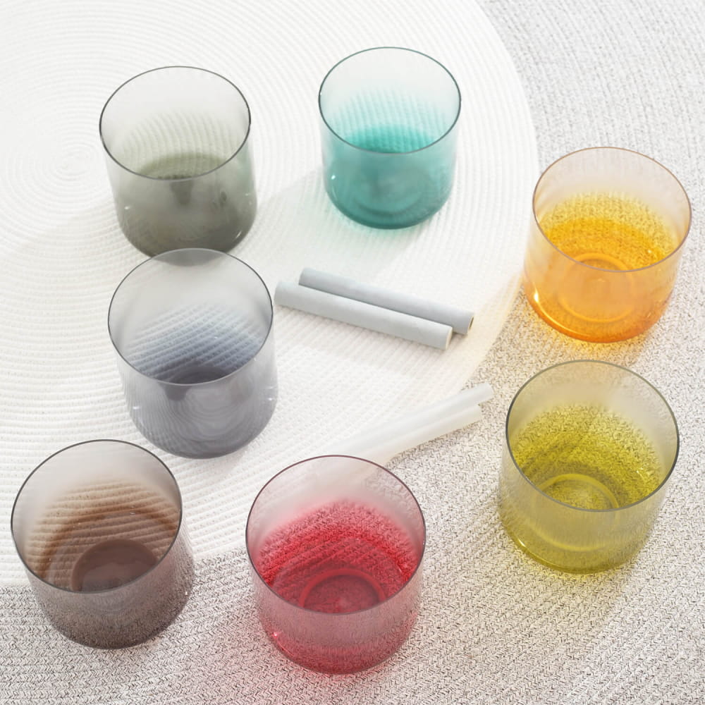 Colorful glass tumblers in a circular pattern showcasing Alchemy Aria Crystal Singing Bowl Set