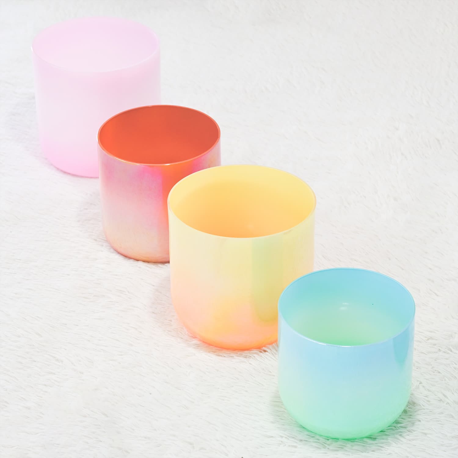 Four colorful gradient glass tumblers in pink, orange, yellow, and blue-green hues