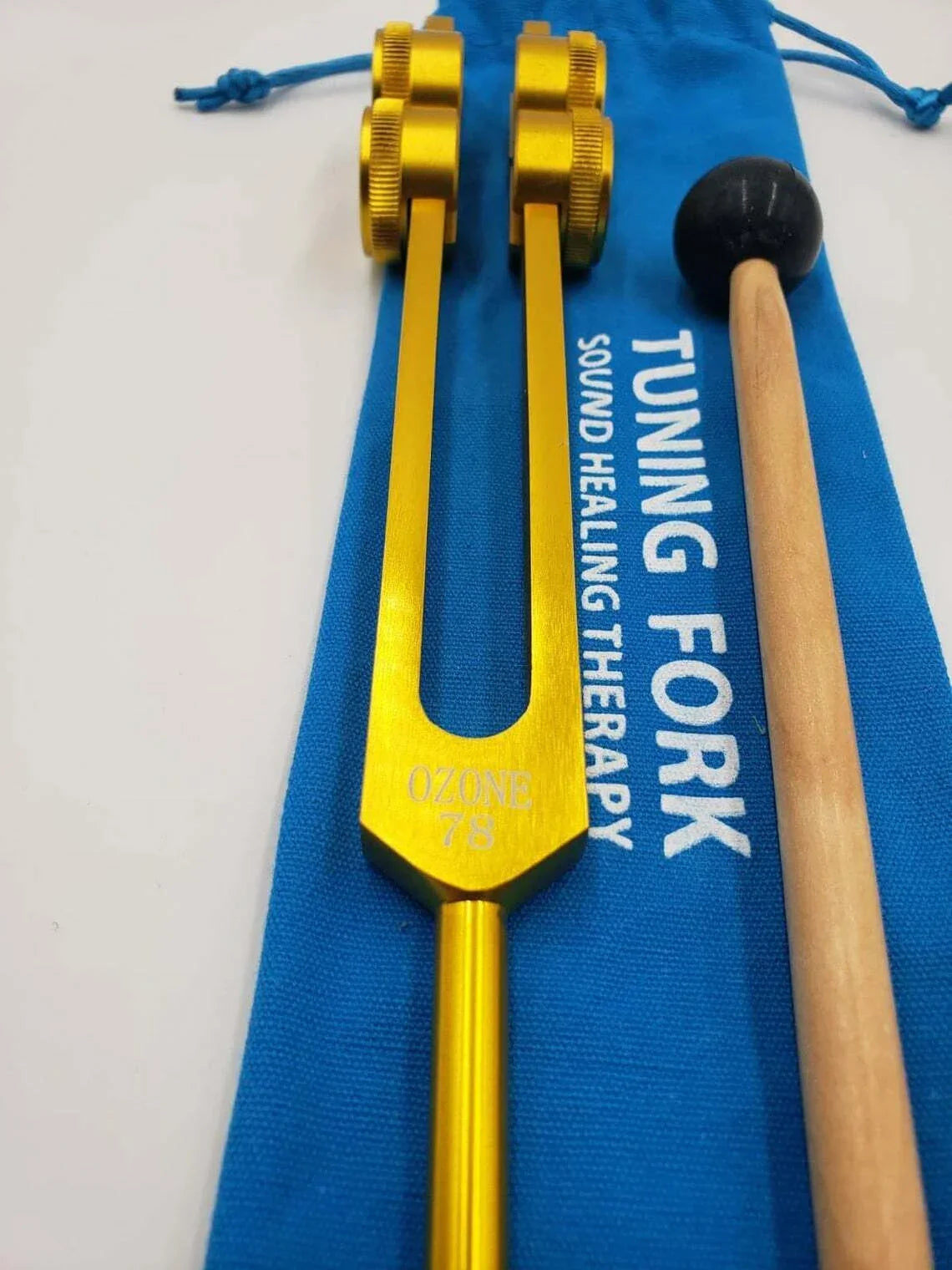 Yellow Tuning Fork with TUNING FORK text on blue pouch from 78 Hz Tuning Fork Set