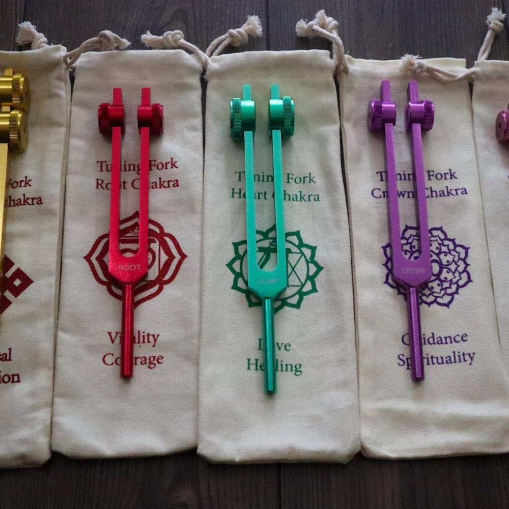 Colorful tuning forks with chakra symbols in cloth pouches for spiritual awakening healing