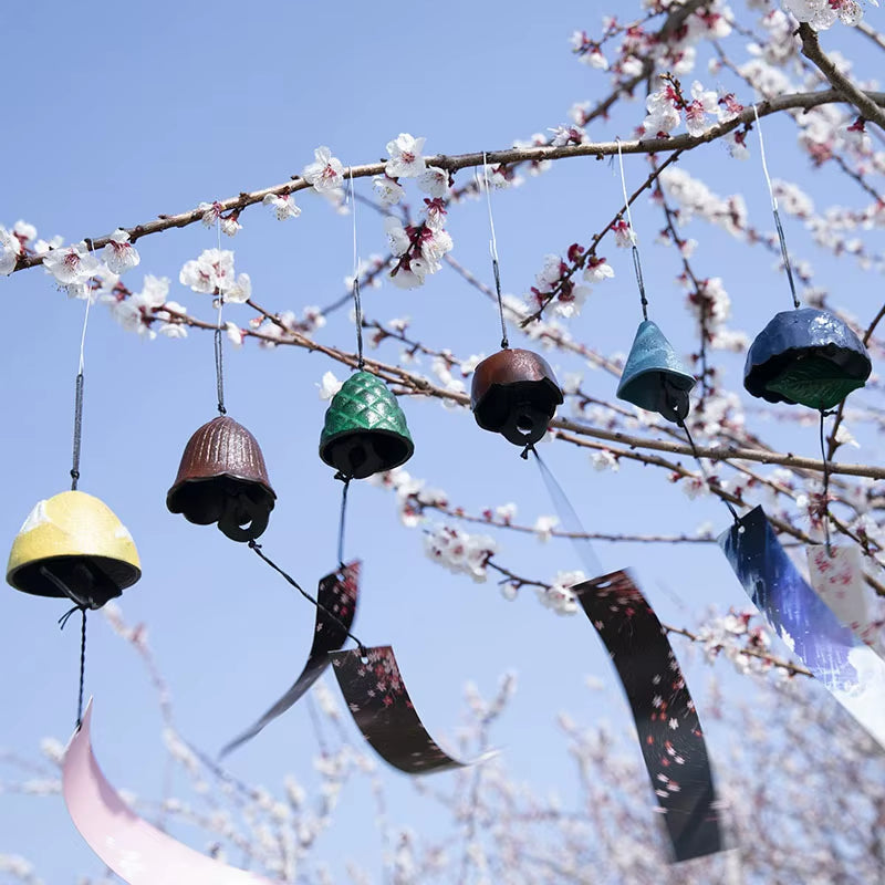 Colorful ceramic wind chimes on a cherry blossom branch for home and garden decor