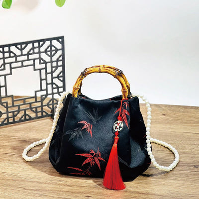 Schwarze Tasche aus Polyester-Baumwolle mit bestickten Blättern und Bambusgriff