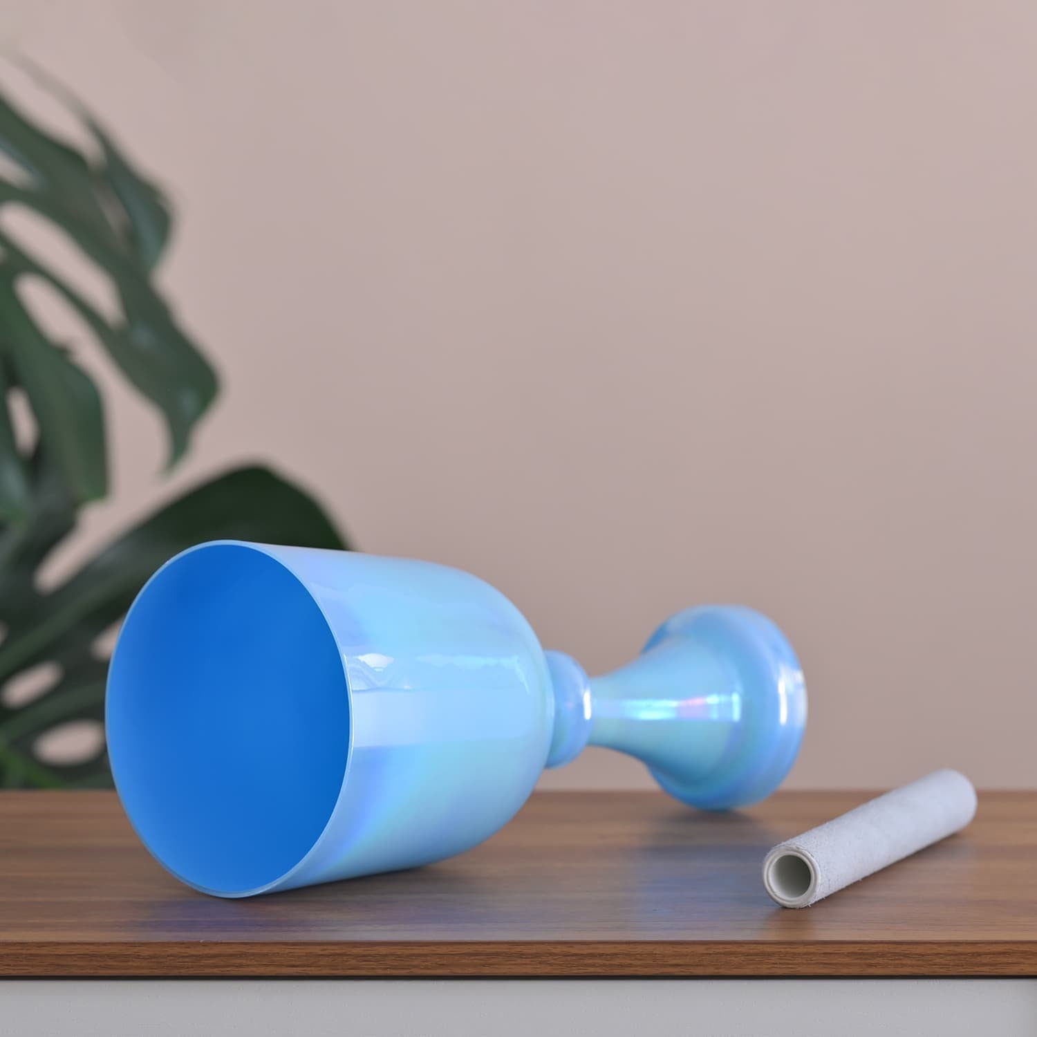 Light blue plastic wine glass on its side, part of Blue Crystal Singing Chalice set