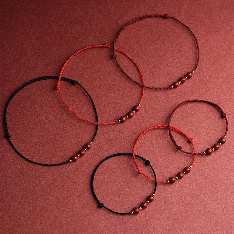 Zinnoberarmband und Fußkettchen mit Glücksbringerschnur