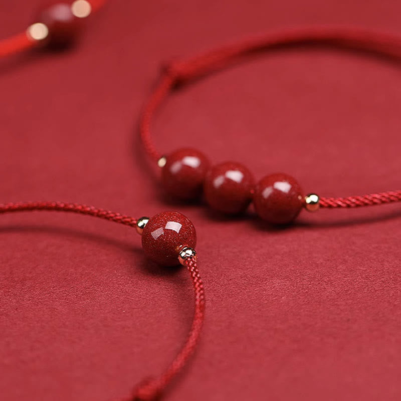 Zinnoberarmband und Fußkettchen mit Glücksbringerschnur