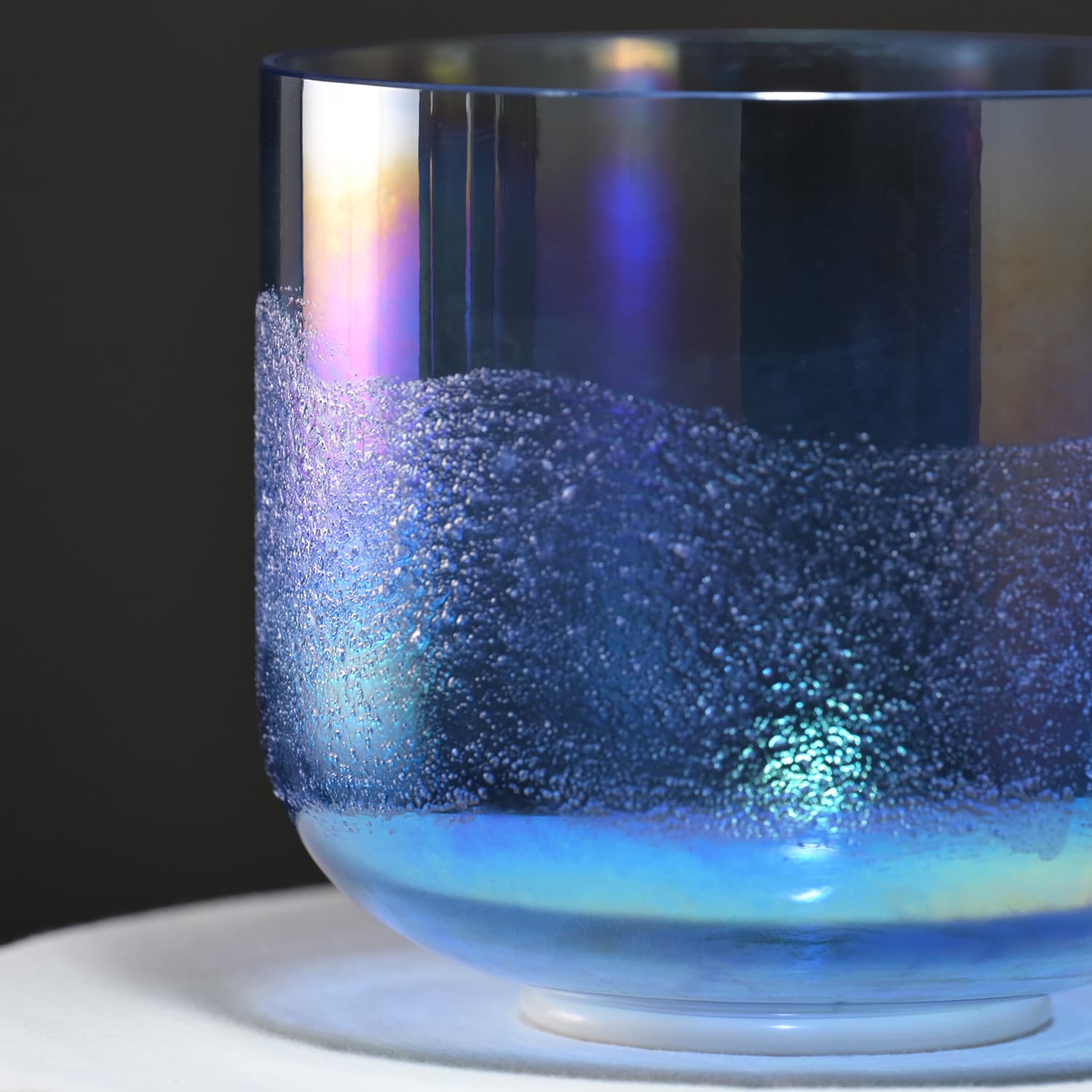 Glass container with swirling blue liquid and bubbles in Crystal Singing Bowl Glacier Sand