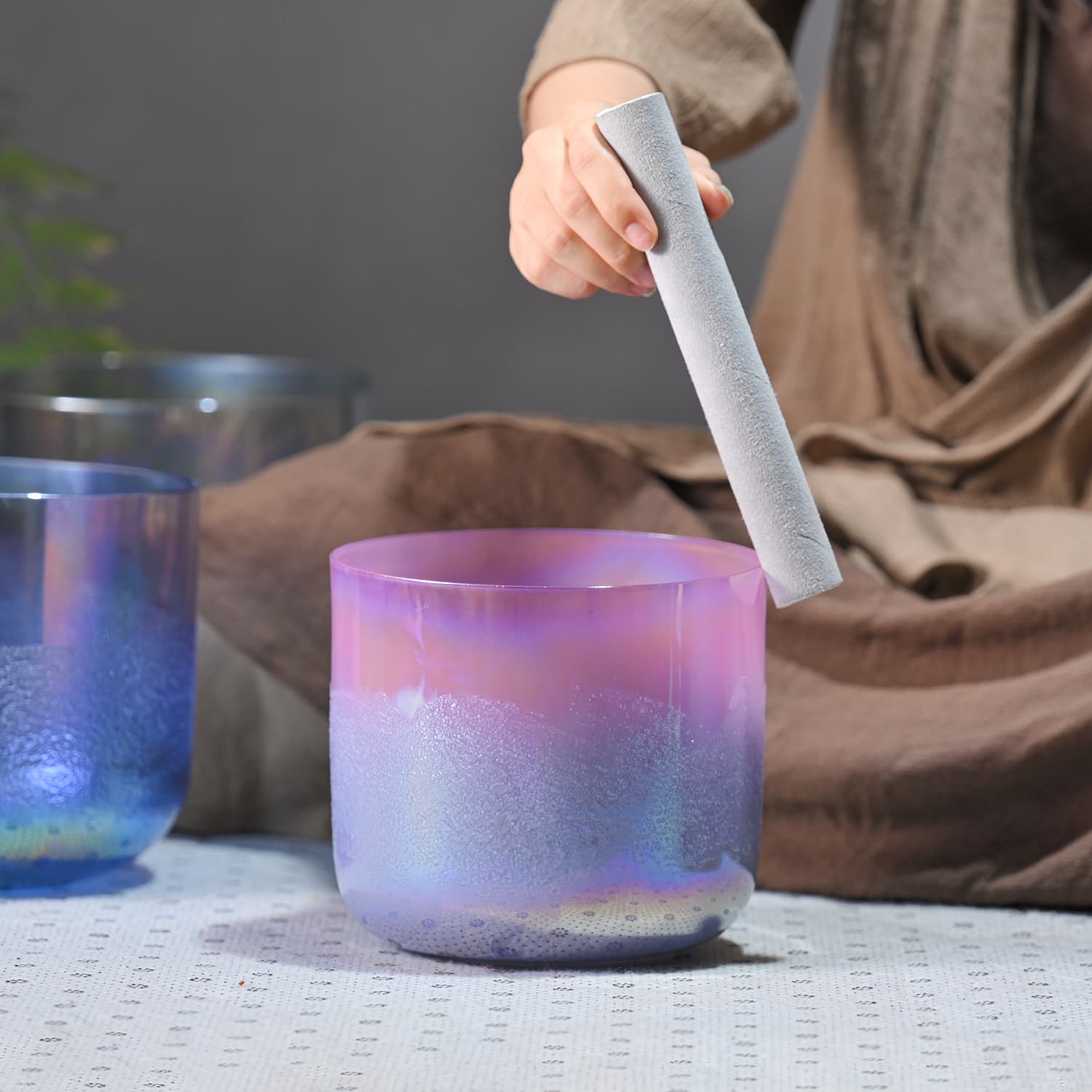 Iridescent Crystal Singing Bowl Neon Sand being played with a mallet for sound healing