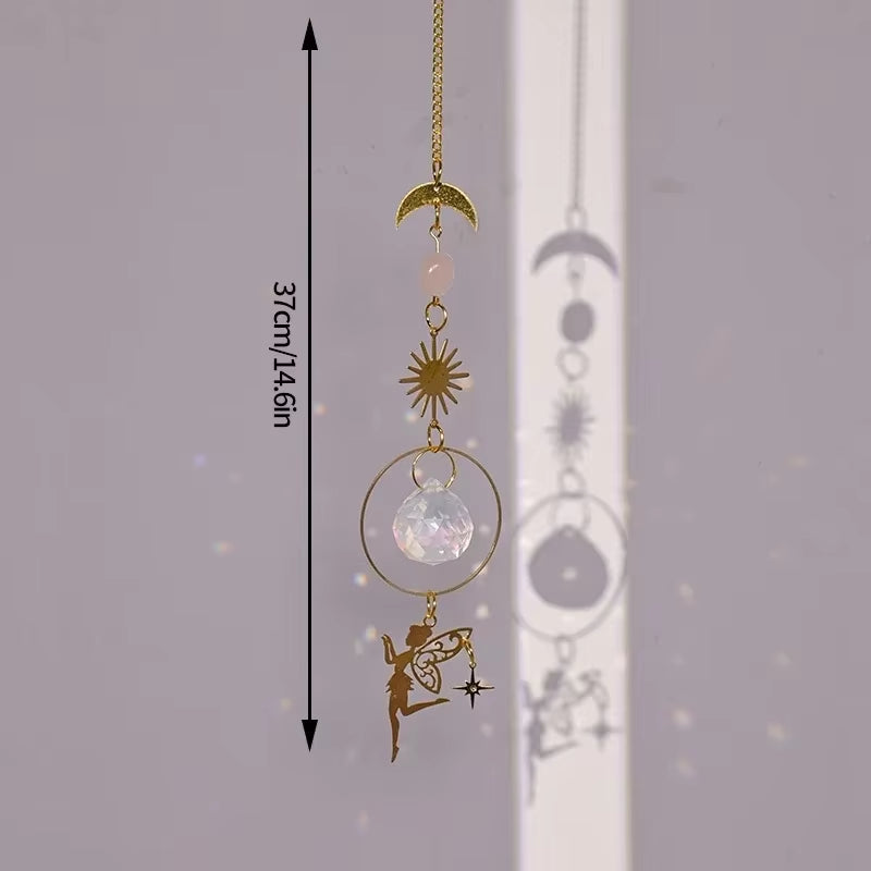 Decorative hanging crystal suncatcher with moon, star, and fairy charms on gold chain